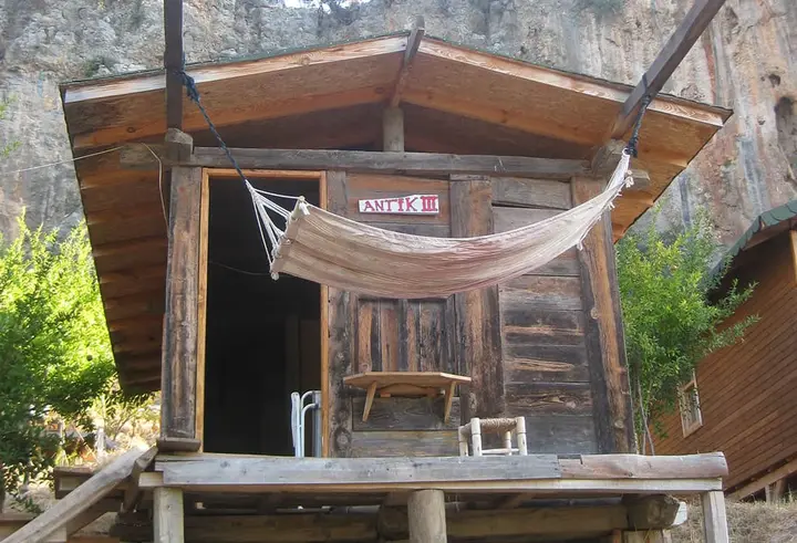 Kapının önüne hamak asılı kazıklı Antik III bungalovu