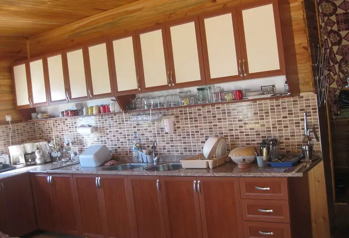 Wooden kitchen with cupboards and mosaic tiles above the counter
