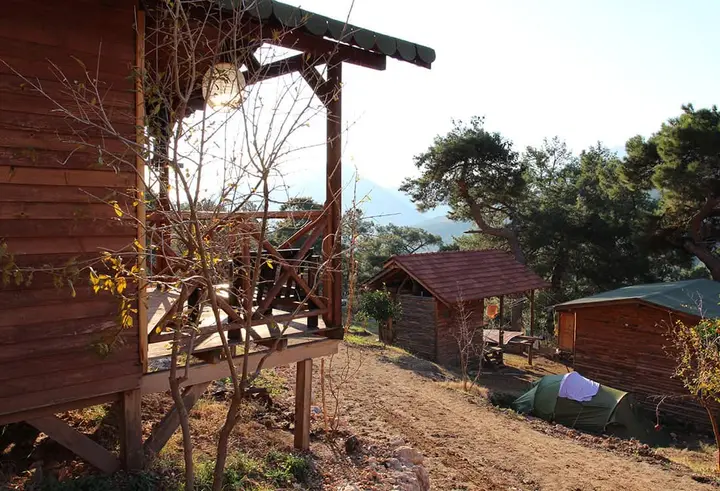 Mandalin terası kirişleri, arkada kırmızı çatılı kulübe ve çadır