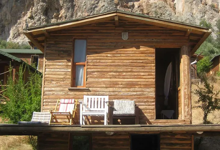 Vorderseite des Bungalows Nar mit weissen Stühlen auf der Veranda