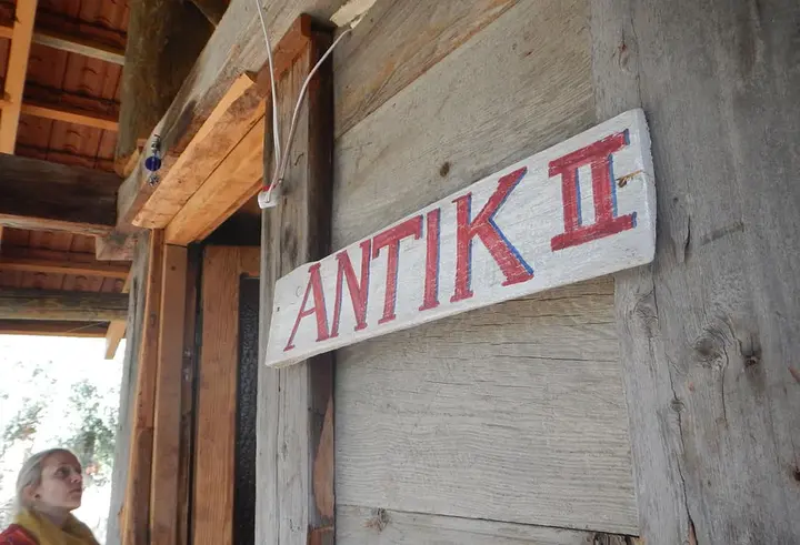 Wooden sign reading Antik II on the bungalow wall