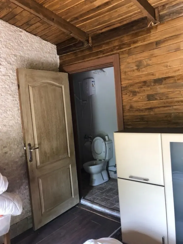 Open bathroom door with toilet and water heater in Erma